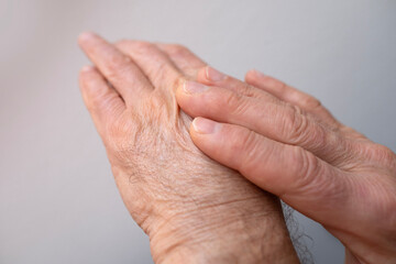 Fototapeta premium Man examining inflamed area on hand, self-massaging for pain relief, Skin health and care, disease prevention and maintenance health, performing self-massage, treatment of rheumatism, skin conditions