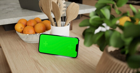 Smartphone place on kitchen table, Green screen telephone, Close up display mobile phone with mock up, Chroma key monitor - 756591569