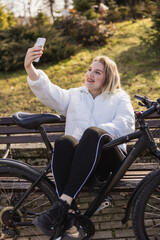 Woman Sitting on Bench Taking Selfie With Phone