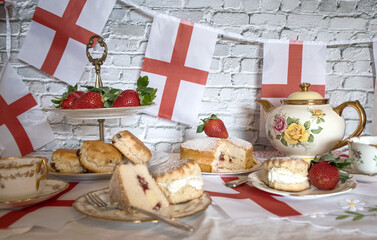 Fototapeta premium Celebrating St Georges day England afternoon team vintage victoria sponge strawberries and cream scones bunting england flag 
