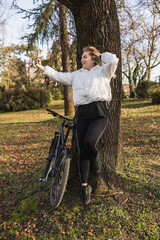 Woman Leaning Against Tree With Bike