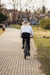 Woman Riding Bicycle Down Brick Road