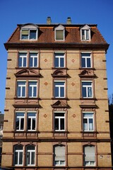 Saniertes altes Wohnhaus mit Fassade in Beige, Braun und Naturfarben vor blauem Himmel im Sonnenschein an der Walter-Kolb-Straße im Stadtteil Sachsenhausen in Frankfurt am Main in Hessen