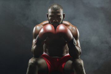 Dramatic front view portrait of muscular African American boxer looking at camera intensely with smoke in background - Powered by Adobe