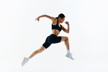 Fototapeta na wymiar Dynamic image of young woman with strong, healthy, sportive body in sportswear in motion, training isolated over white studio background. Concept of sport, health and body care, fitness app