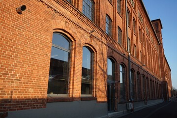 Fensterfront einer alten Fabrik mit Fassade aus Backstein vor blauem Himmel im Sonnenschein in der Klassikstadt im Stadtteil Fechenheim in Frankfurt am Main in Hessen