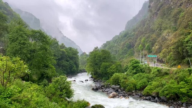Storm clouds over mountains of Jang town deep in the  jang valley in tawang district of arunachal pradesh and surrounded by high mountains on a bright morning rainy day in arunachal pradesh in India.