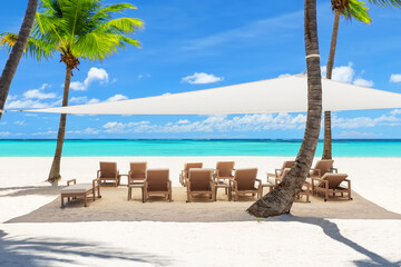 Beach chairs under a canopy on a beautiful white sand beach in Punta Cana, Dominican Republic.