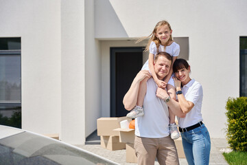 Fototapeta na wymiar Joyful family in the courtyard of a new house