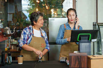 The beautiful Asian daughter of the cafe owner Receiving call from the phone to receive orders...