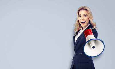 Happy excited business woman, hold megaphone mega phone bullhorn loud speaker shout advertise sale ad offer. Businesswoman use loudspeaker bull horn, isolated against grey wall plain background.