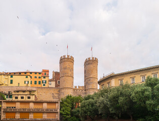 Cityscape of the city of Genoa with residential buildings and towers of the city gate of Porta Soprana, Italy.