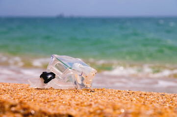Shallow depth of field snorkeling mask lies on a sandy beach overlooking the sea and sky, no people