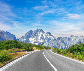 Naklejka premium Country road with rocky mountains in the background.