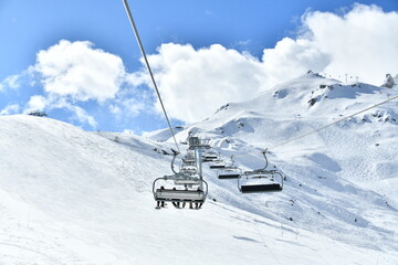 Fototapeta na wymiar Ski lift by winter going up on the slopes in Courchevel ski resort 