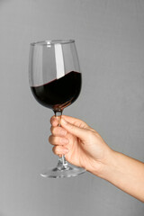 Woman with glass of red wine on grey background, closeup