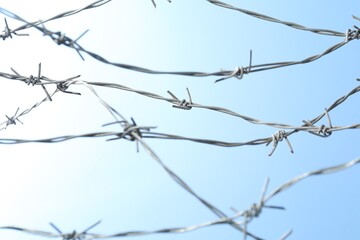 Shiny metal barbed wire on light background