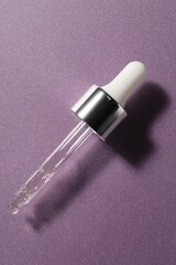 Pipette with moisturizing serum on violet background, top view