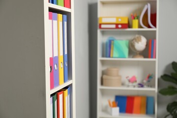 Colorful binder office folders on shelving unit indoors