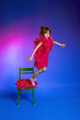 little girl jumping from a chair