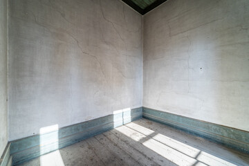 Old, grunge empty room from abandoned house without furniture. Light from the windows. Background with copy space
