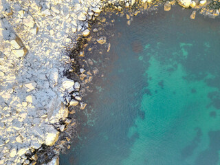Above the frozen chaos where ice chunks scatter along the snowy coastline.