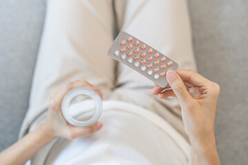 Contraception and pregnancy, menstruation concept, birth control pills asian young woman hand...