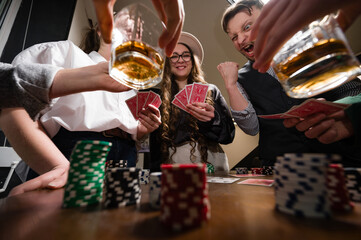 A team rejoices at a poker win against the background of glasses of whiskey.