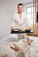 Man brought breakfast with champagne to his young wife in bed