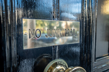 No Junk Mail sign on black British residential door.