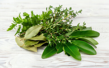 Bouquet of herbs composed of bay leaf, thyme and parsley, on a wooden white table. Fresh bouquet garni on wooden white table