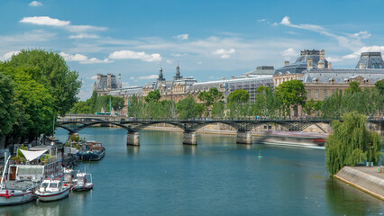 Touristic boat passes below Pont des Arts, on boat station on Seine river timelapse in Paris.