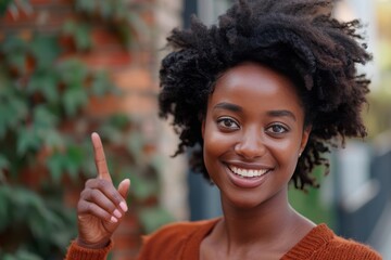 Happy African American woman gesturing upwards with a smile.