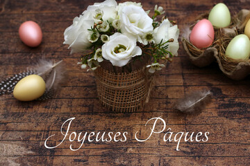 Carte de voeux Joyeuses Pâques : œufs de Pâques et bouquet de fleurs sur une vieille planche de...