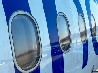 The blue and white airplane has a large window on the side