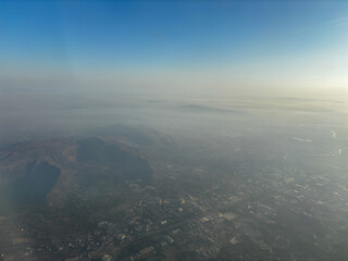 A city is seen from above with a hazy atmosphere