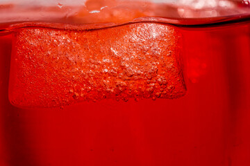 Red colored drink in a glass with ice macro photography as per likes of Rooh Afza and Jam e Shirin