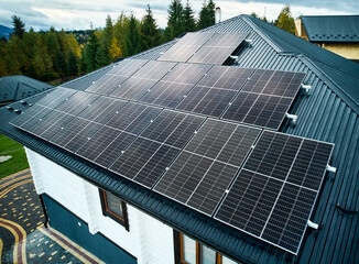 Aerial view of new modern house cottage with solar photovoltaic panel system on roof. Concept of...