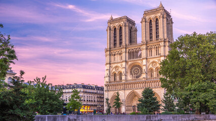 Front view of Notre Dame De Paris cathedral day to night timelapse after sunset.