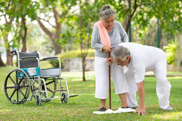 senior woman helping and holding hands her husband in the park