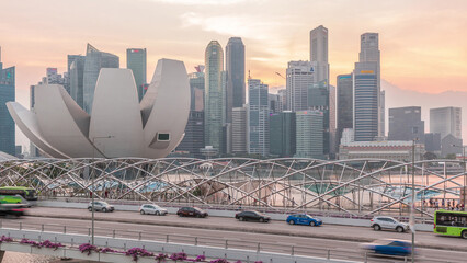 Aerial view over Helix Bridge and Bayfront Avenue with traffic day to night timelapse at Marina Bay, Singapore