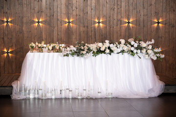 Main table at a wedding reception with beautiful fresh flowers. Wedding day.