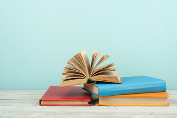 Open book, hardback colorful books on wooden table. Back to school. Copy space for text. Education business concept.