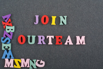 JOIN OUR TEAM word on black board background composed from colorful abc alphabet block wooden letters, copy space for ad text. Learning english concept.