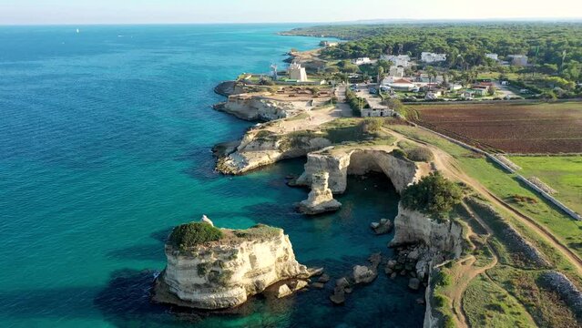 Stunning seascape with cliffs rocky arch and stacks (Faraglioni) at Torre Sant Andrea, Salento coast, Puglia region, Italy. Beautiful cliffs and sea stacks of Sant'Andrea, Salento, Apulia, Italy