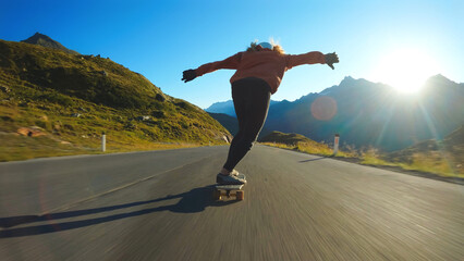 woman skateboarding and making tricks between the curves on a mountain pass.