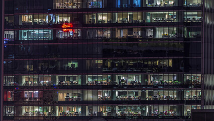 Modern office building with big windows at night timelapse, in windows light shines