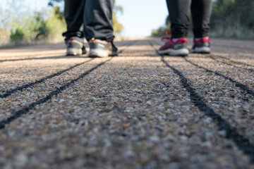 Close-up detail of lines on the asphalt with runners in the background.