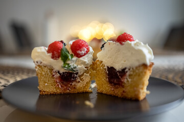 Cupcake with raspberries and blackberries, cut in half on a plate. Photo