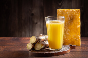 Glass of sugarcane juice with fried pastry. Typical Brazilian snack.